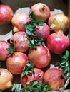 Red pomegranates with green leaves in a box Royalty Free Stock Photo