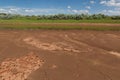 Mud along the edges of a drying water hole dried and cracks