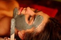 Mud facial mask of woman in spa salon. Face massage . Royalty Free Stock Photo