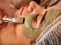 Mud facial mask of woman in spa salon. Face massage . Royalty Free Stock Photo