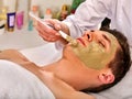 Mud facial mask of woman in spa salon. Face massage. Royalty Free Stock Photo