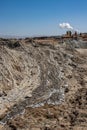 Mud flow from geothermal volcano pots at Salton Sea with energy generating plant in the background Royalty Free Stock Photo