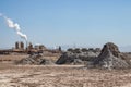 Mud pots at Salton Sea with geothermal generating plant in the background Royalty Free Stock Photo