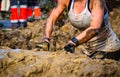 Mud race runners, defeating obstacles by using ropes. Details of the hands