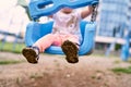 Mud-stained sandals on the feet of a child on a swing. Close-up Royalty Free Stock Photo