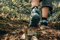 Muddy boots of hiker on forest trail. Traveler feet on ground with fallen leaves. Close up of the sole of dirty shoes. Hiking