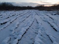 A muddy country road with tire ruts covered with snow in winter Royalty Free Stock Photo