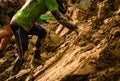 Muddy obstacle race runner in action. Mud run