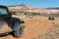 Four-wheel drive vehicle on a curving dirt road driving towards a colorful high desert peak in Ghost Ranch, New Mexico Royalty Free Stock Photo