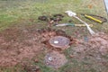 Muddy mess in yard where utility workers have been digging out water meters to fix a leak...with their equipment scattered around Royalty Free Stock Photo