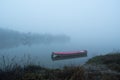 Muddy path leads to moored boat in fog Royalty Free Stock Photo