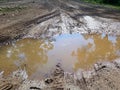 Muddy puddle on a dirty rural road Royalty Free Stock Photo