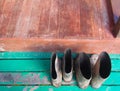 Muddy rubber boots on a wooden surface