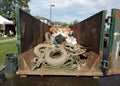 Muddy Trash in a Dumpster Collected During a Cleanup Event, Tires Covered in Mud