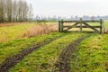 Muddy wheel tracks to a closed gate