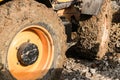 Muddy wheels of an excavator bulldozer truck working on a construction site