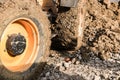 Muddy wheels of an excavator bulldozer truck working on a construction site