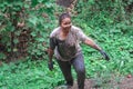 A muddy woman walking up a hill