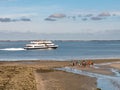 Mudflat hiking and ferry in WittdÃÂ¼n channel, Amrum island, North Frisia, Schleswig-Holstein, Germany Royalty Free Stock Photo