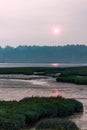 vertical shot of mudflats and wetlands under sunset in hazy smoke filled skys