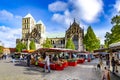 View to catholic cathedral of MÃÂ¼nster with food market in front. People enjoy shopping at the open air market