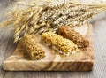 Muesli bars on wooden board with ears of wheat, oats, rye bouquet Royalty Free Stock Photo