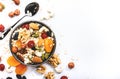 Muesli bowl, organic ingredients for healthy breakfast Granola, nuts, dried fruits, oatmeal, whole grain flakes on white