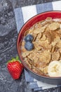 Muesli. Breakfast, healthy food and diet. Muesli with milk and fruit in a plate on a black marble top. Woman's hand with Royalty Free Stock Photo