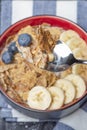 Muesli. Breakfast, healthy food and diet. Muesli with milk and fruit in a plate on a black marble top. Woman's hand with Royalty Free Stock Photo