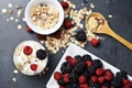 Muesli cereals, yogurt and fresh berries on dark background, preparing a healthy and delicious breakfast with natural ingredients Royalty Free Stock Photo