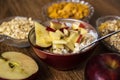 Muesli with dried fruit, milk and sliced red apple on wooden table Royalty Free Stock Photo