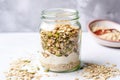 muesli mix in a glass jar with cooking oats at the side