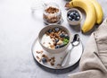 Muesli with vegetarian yogurt, banana and blueberries in a bowl on a gray texture background. Healthy and dietary homemade granola Royalty Free Stock Photo