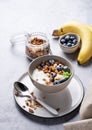 Muesli with vegetarian yogurt, banana and blueberries in a bowl on a gray texture background. Healthy and dietary homemade granola Royalty Free Stock Photo