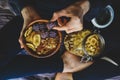 Muesli in wooden bowl with cranberries and nuts in hands Royalty Free Stock Photo