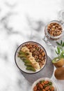 Muesli with yogurt, banana and kiwi on a light background with shadows