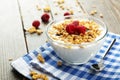 Muesli with yogurt and raspberries in a bowl on a brown wooden background. Royalty Free Stock Photo