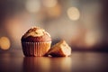 a muffin with a bite taken out of it sitting on a table with a blurry background of lights Royalty Free Stock Photo