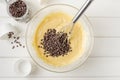 Muffin dough with chocolate chips in a bowl on a white wooden background. Recipe step by step. Top view Royalty Free Stock Photo