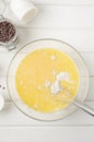 Muffin dough with chocolate chips in a bowl on a white wooden background. Recipe step by step. Top view Royalty Free Stock Photo