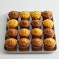 Muffins arranged in a 4x4 grid on a metal baking tray. The selection includes various Royalty Free Stock Photo