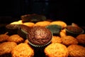 Muffins with chocolate and nuts. in the background a cook in an apron