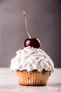 Muffins and cupkake with whipped cream decorated with strawberry on top on gray background Royalty Free Stock Photo