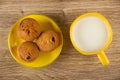 Muffins with raisin in yellow saucer, cup of milk on table . Top view Royalty Free Stock Photo