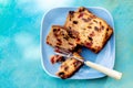 Muffins with raisins on a rustic wooden table. Fruitcake or slices cupcake on a blue plate.