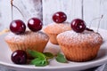 Muffins topped with cherries and sugar powder