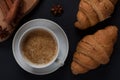 A mug of aromatic coffee with cinnamon sticks on a dark background