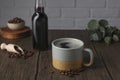Mug of aromatic coffee, syrup and beans on wooden table Royalty Free Stock Photo