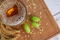 Mug with beer, fresh hops and ears of wheat on white wooden table, top view. Space for text Royalty Free Stock Photo