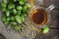 Mug with beer, fresh hops and ears of wheat on wooden table, top view Royalty Free Stock Photo